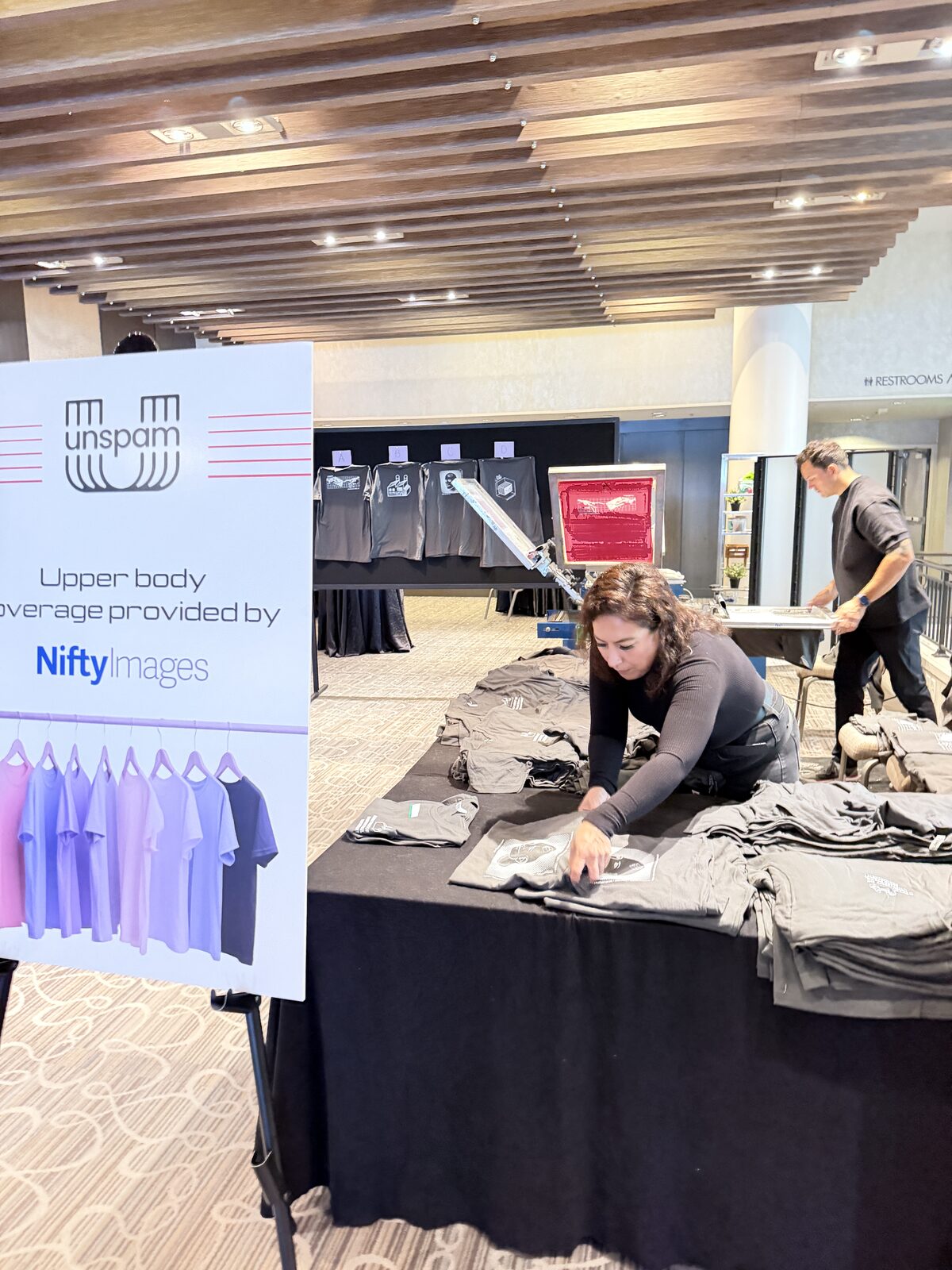 Conference merch table stacked with freshly printed company shirts